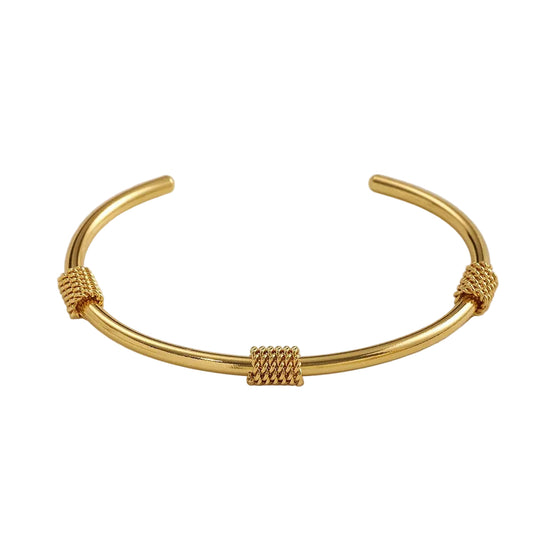 Gold bracelet on a light gray background